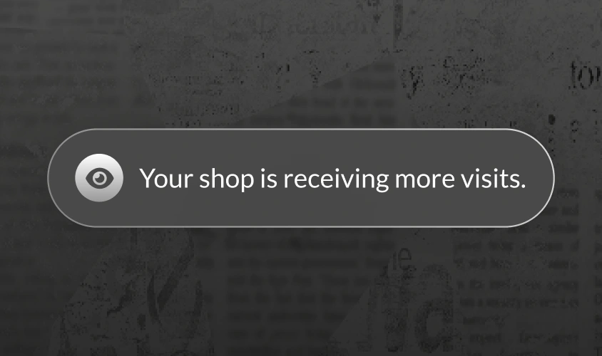 Notification banner: 'Your shop is receiving more visits.' with an eye icon on a dark rounded-pill banner and subtle glow, over a blurred background